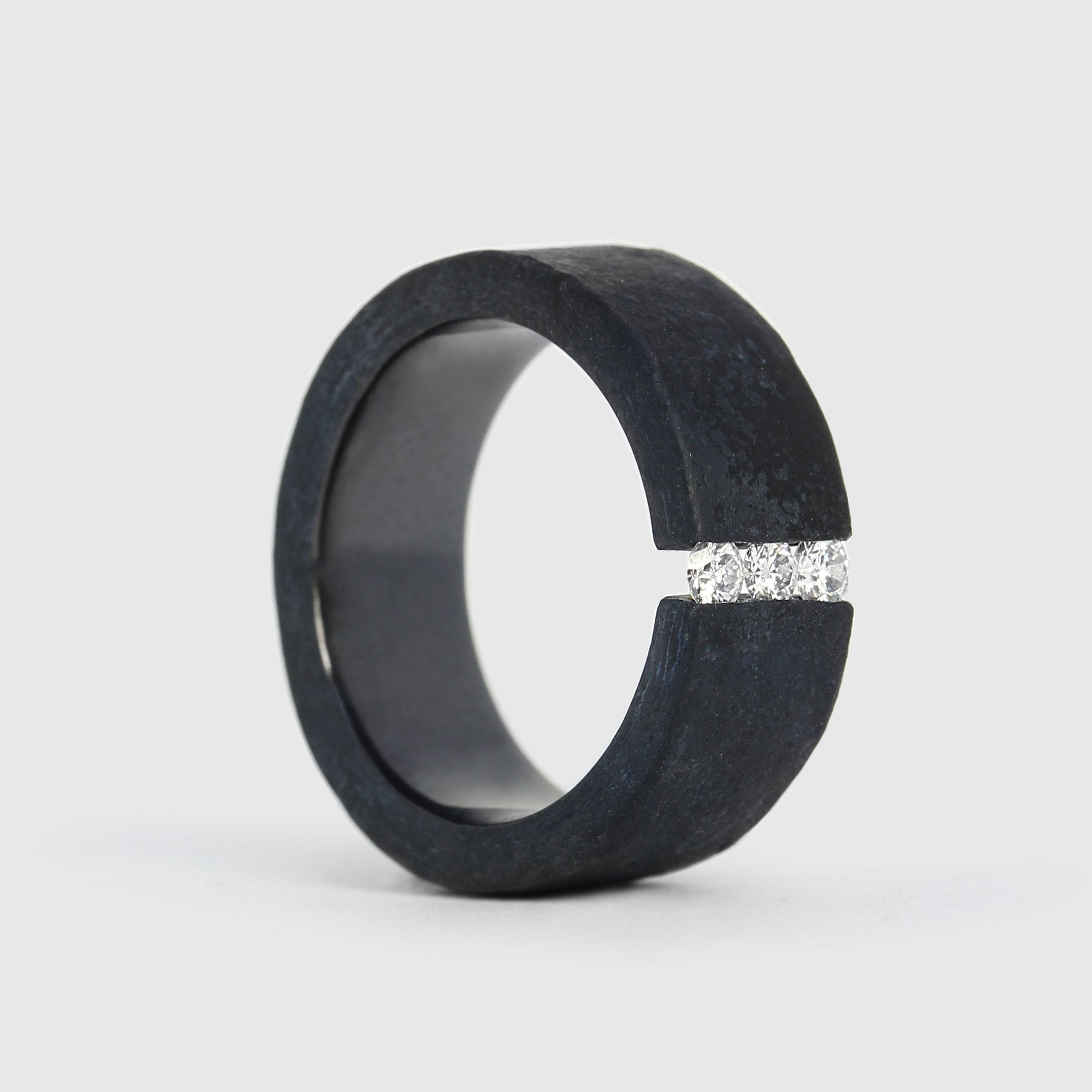 A black niobium ring with a matt finish and a band of white diamonds set on the top surface.