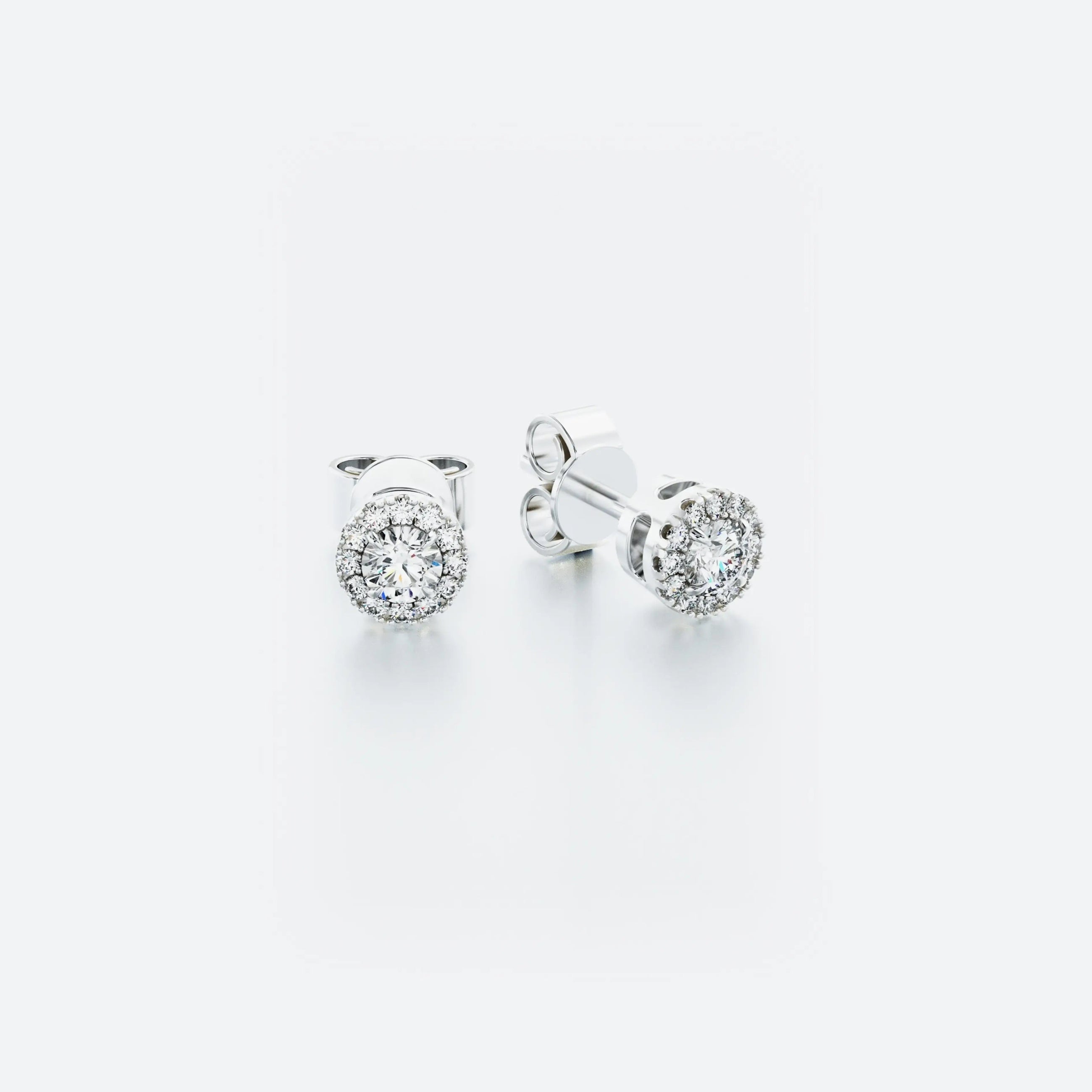 A pair of 14k white gold halo stud diamond earrings with a central diamond surrounded by a halo of pavé-set diamonds.