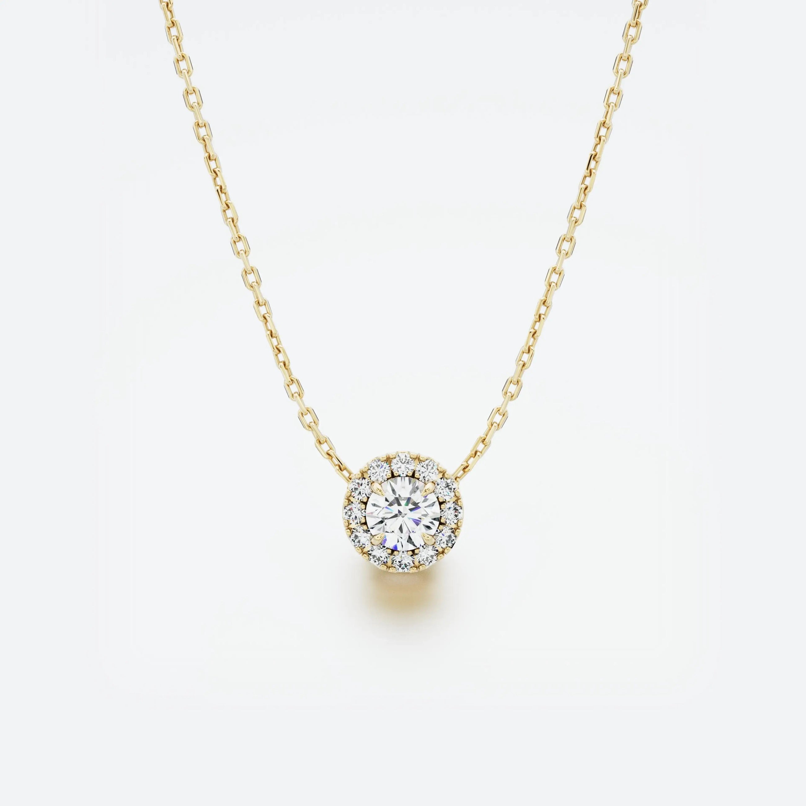 Yellow gold necklace with a round diamond pendant on a light gray background