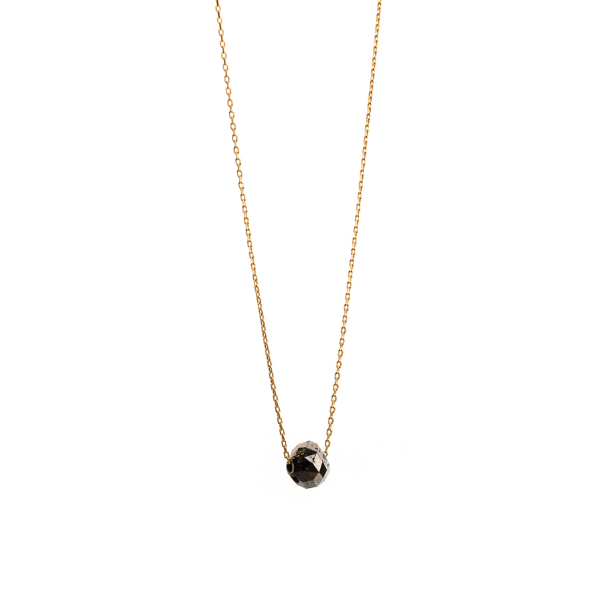 A delicate gold necklace with a faceted diamond pendant, displayed on a clean white background.
