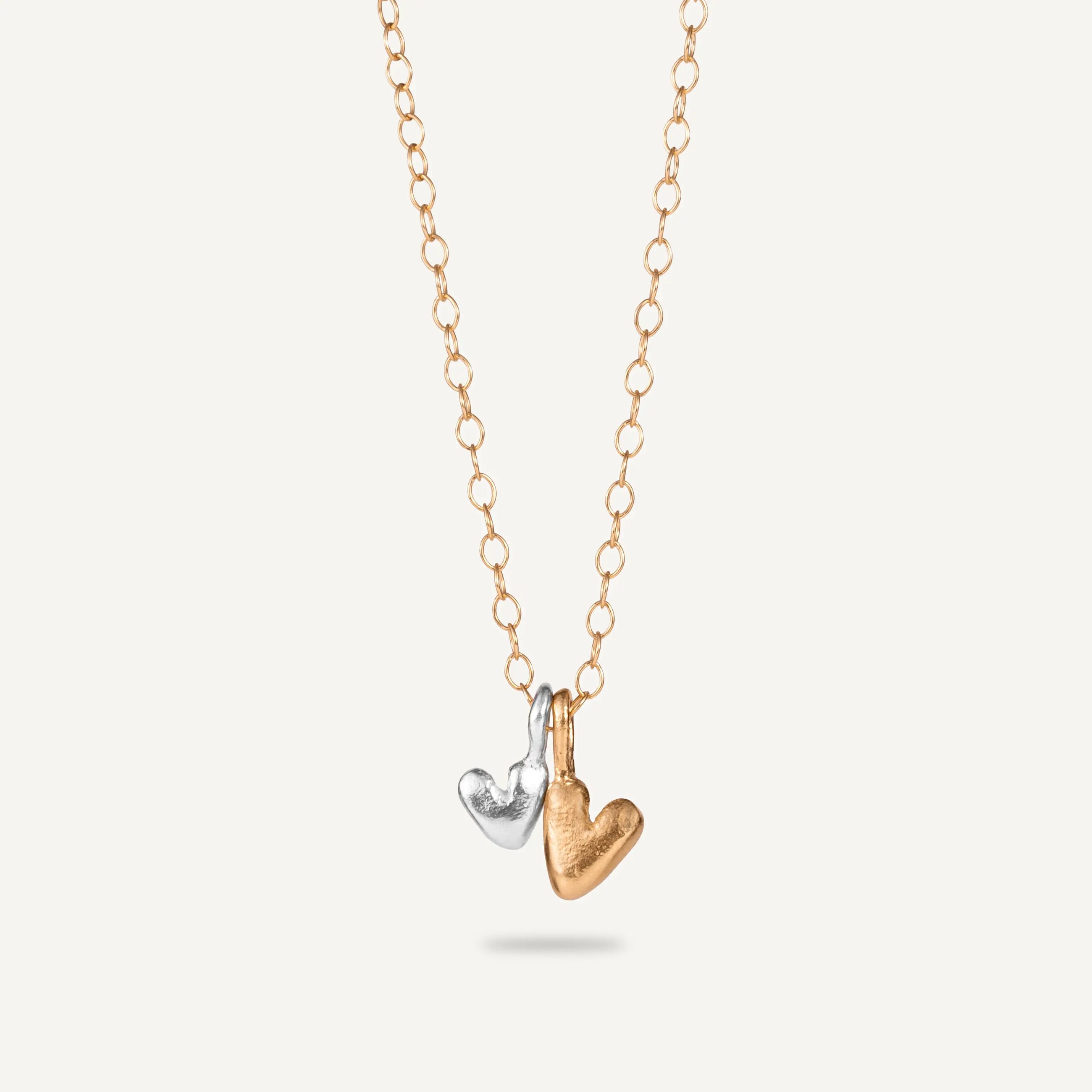 A gold plated silver necklace with a heart-shaped pendant.