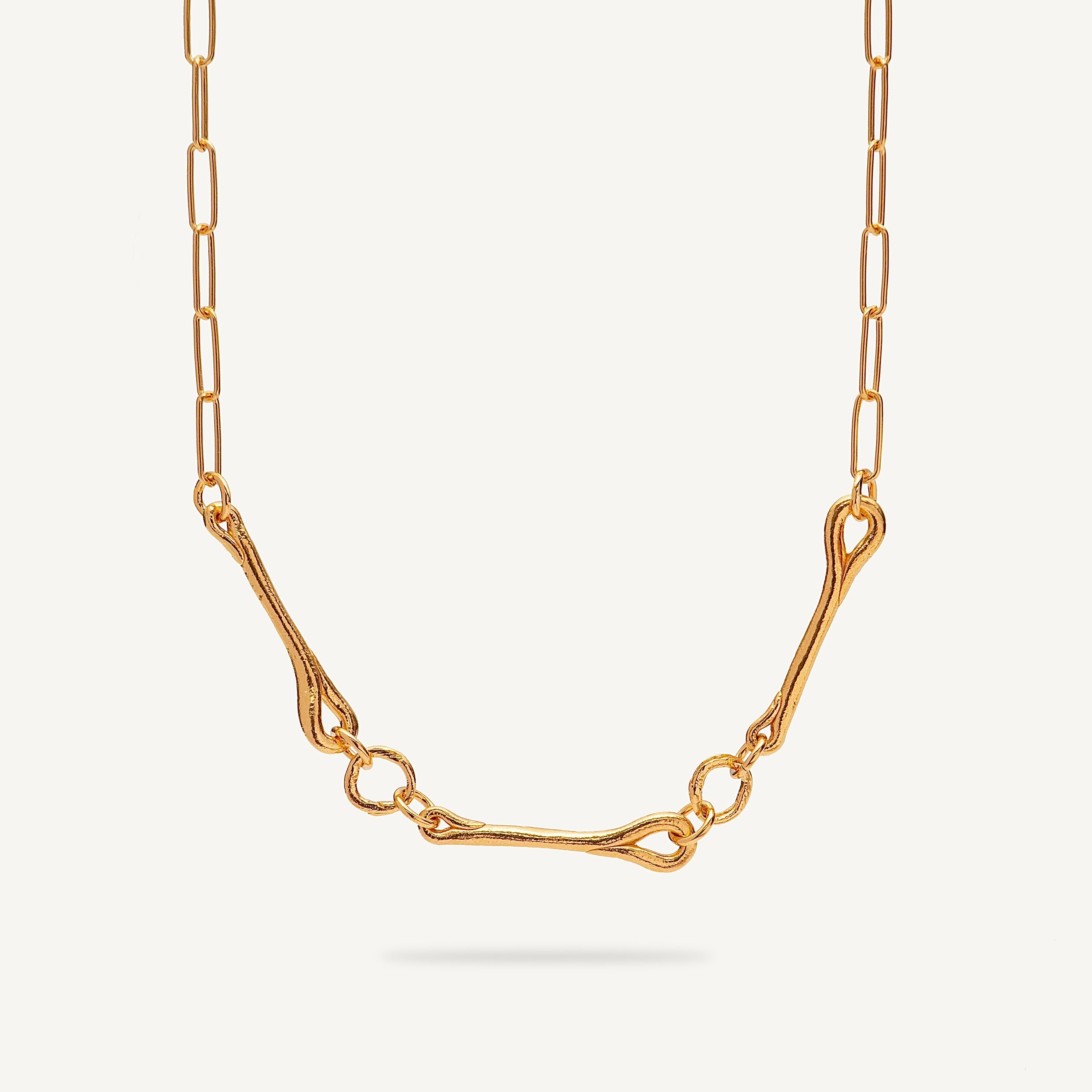 Gold necklace on a light beige background