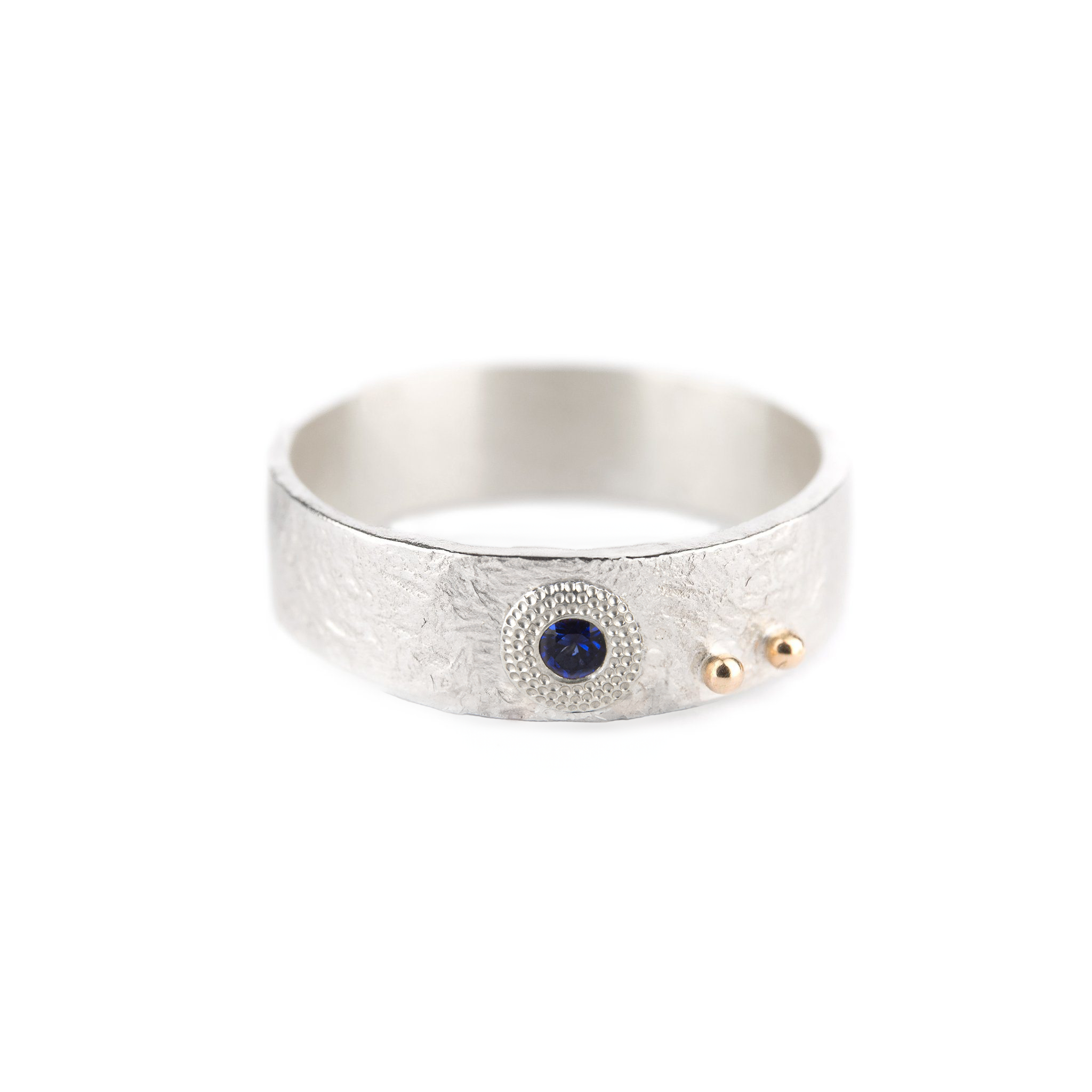 Silver ring with a blue sapphire and gold accents on a white background