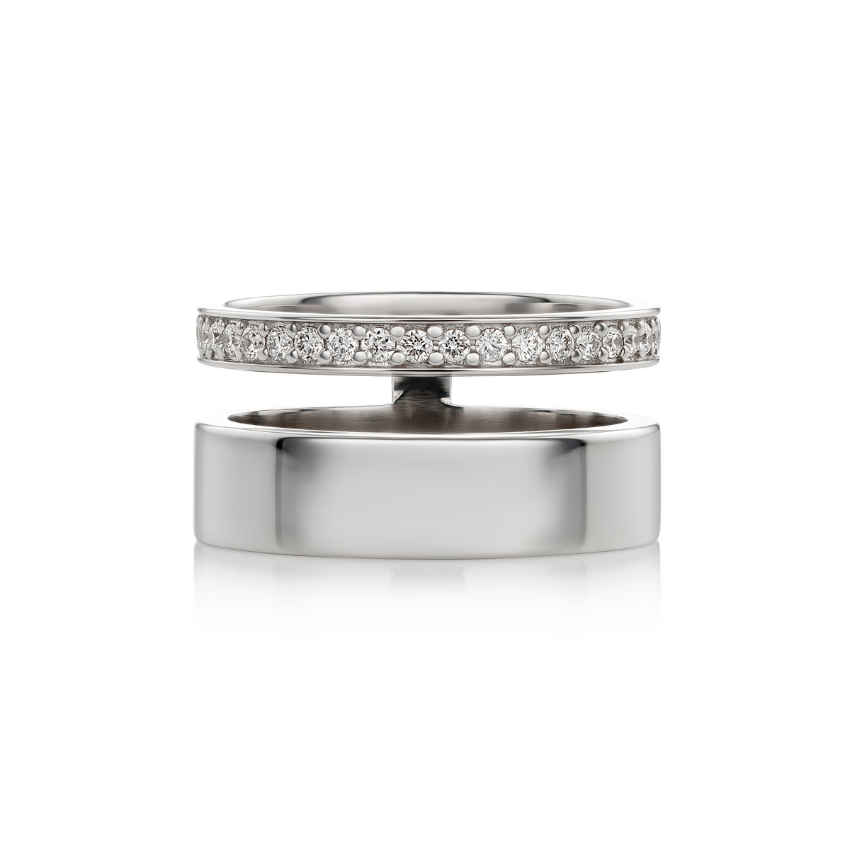 A polished white gold ring shown open, with one half featuring a row of clear pavé stones and the other half plain, on a white background.