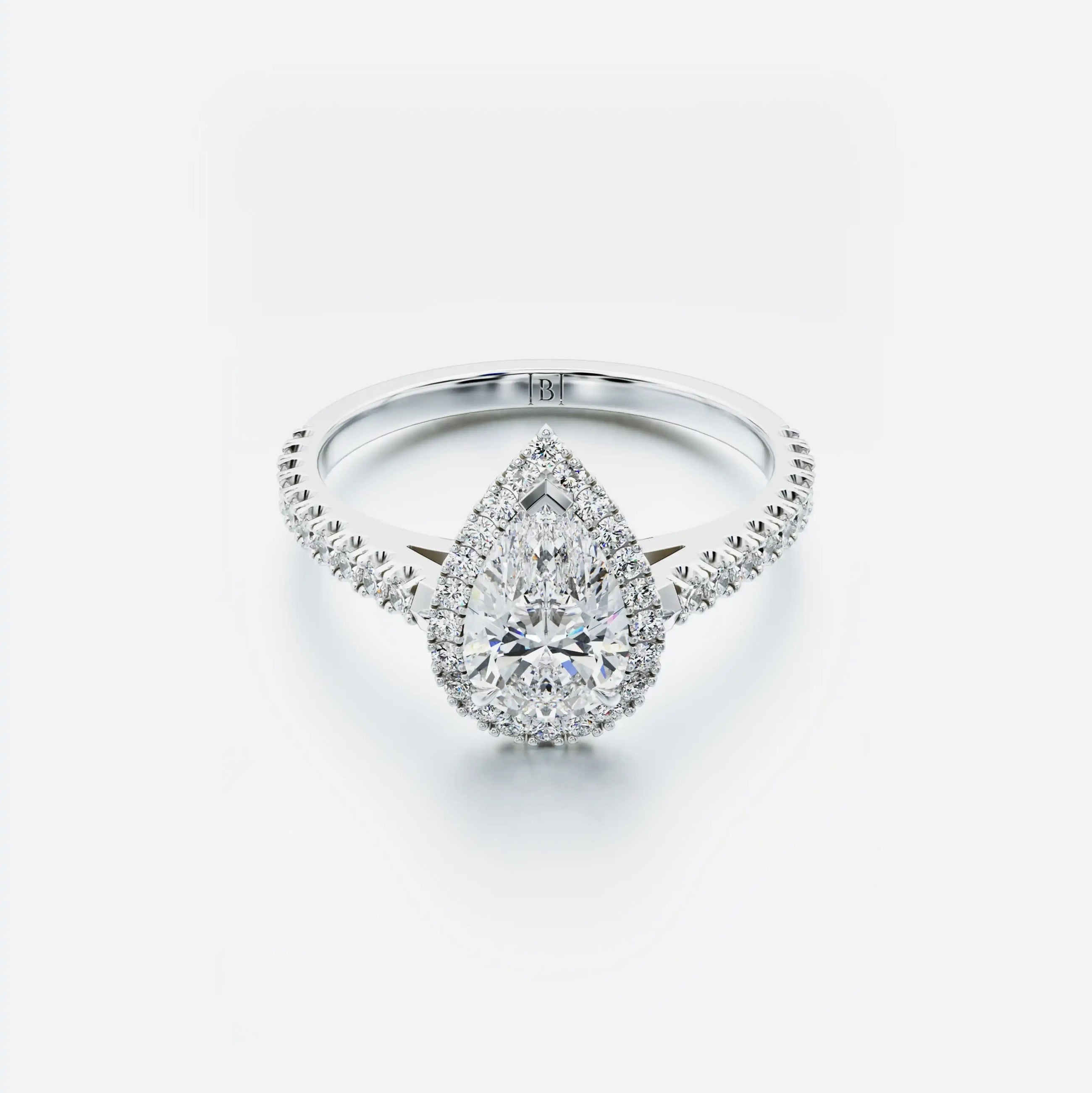Diamond ring with a pear-shaped center stone on a white background