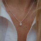 Silver necklace with a pendant worn by a person