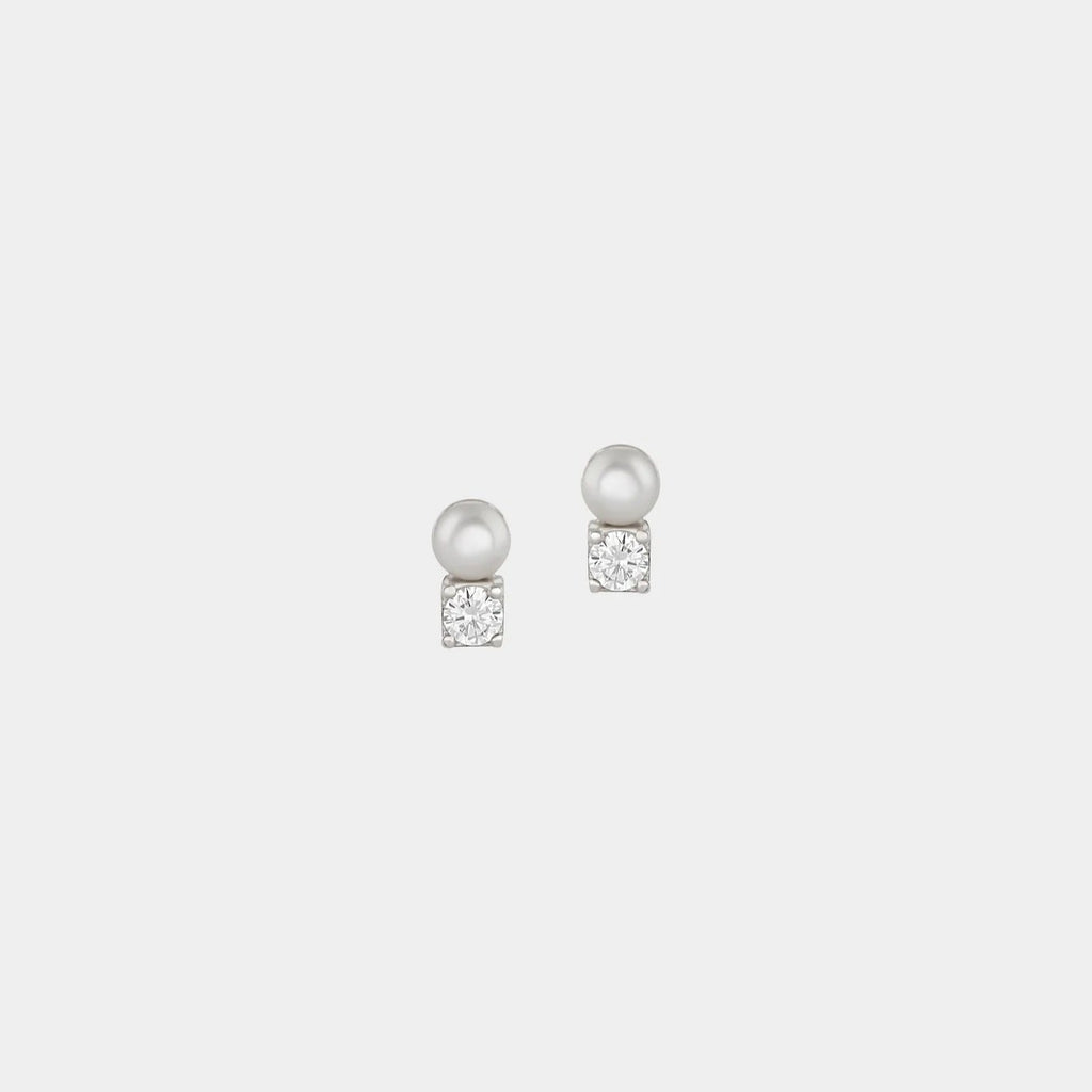 Pair of pearl earrings on a light gray background