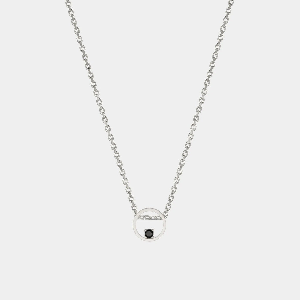 Silver necklace with a small round pendant on a light gray background