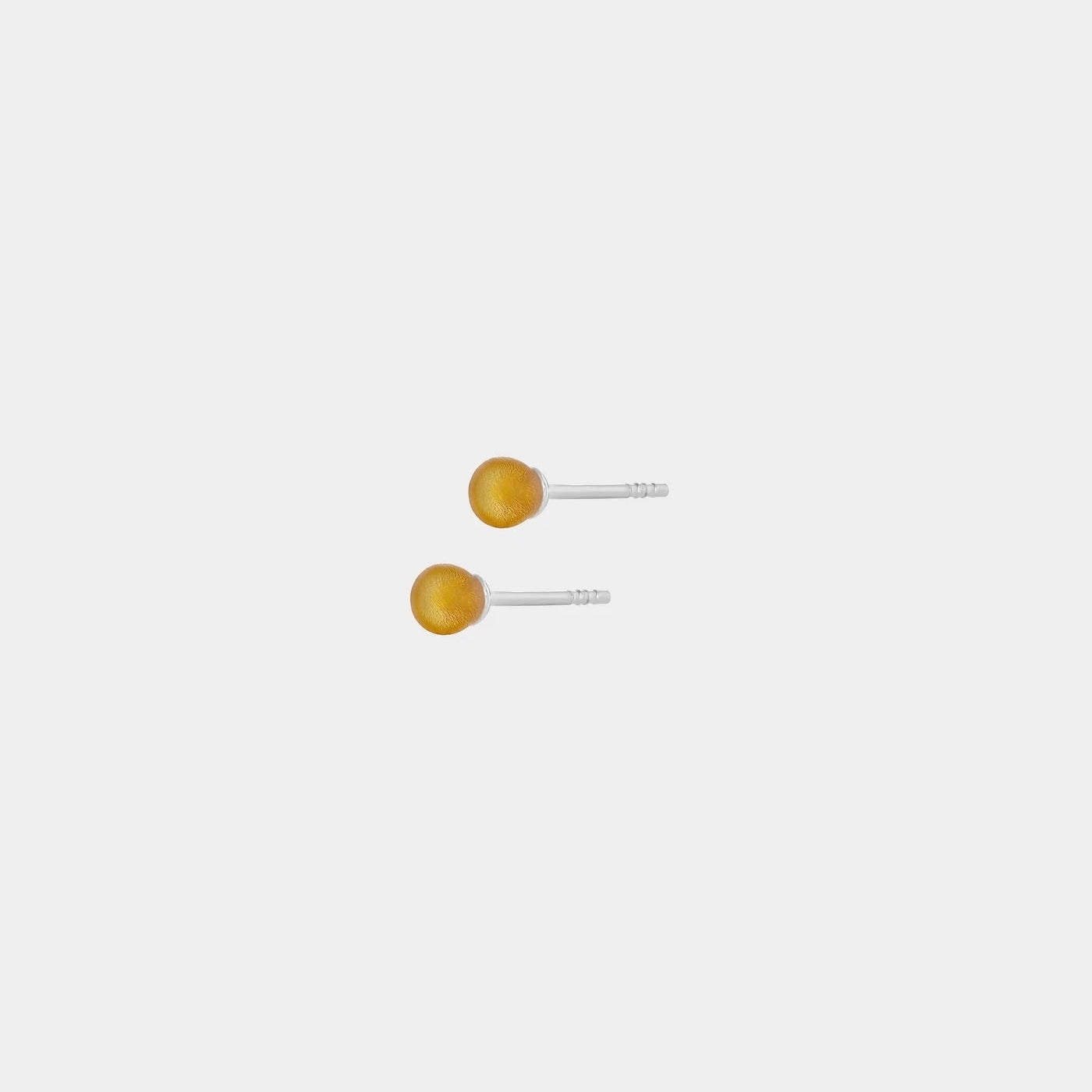 Silver stud earrings, featuring Baltic amber by Adele Notes.