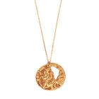 Gold coin pendant necklace on a white background