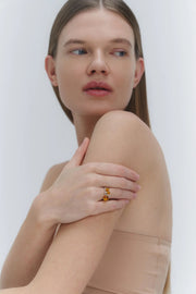 A sleek gold ring featuring a medium size natural Baltic amber stone.