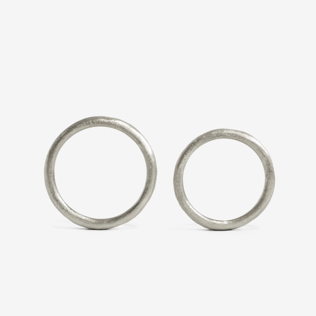 A hand-forged, 24k platinum rings with a textured surface, displayed on a white background.