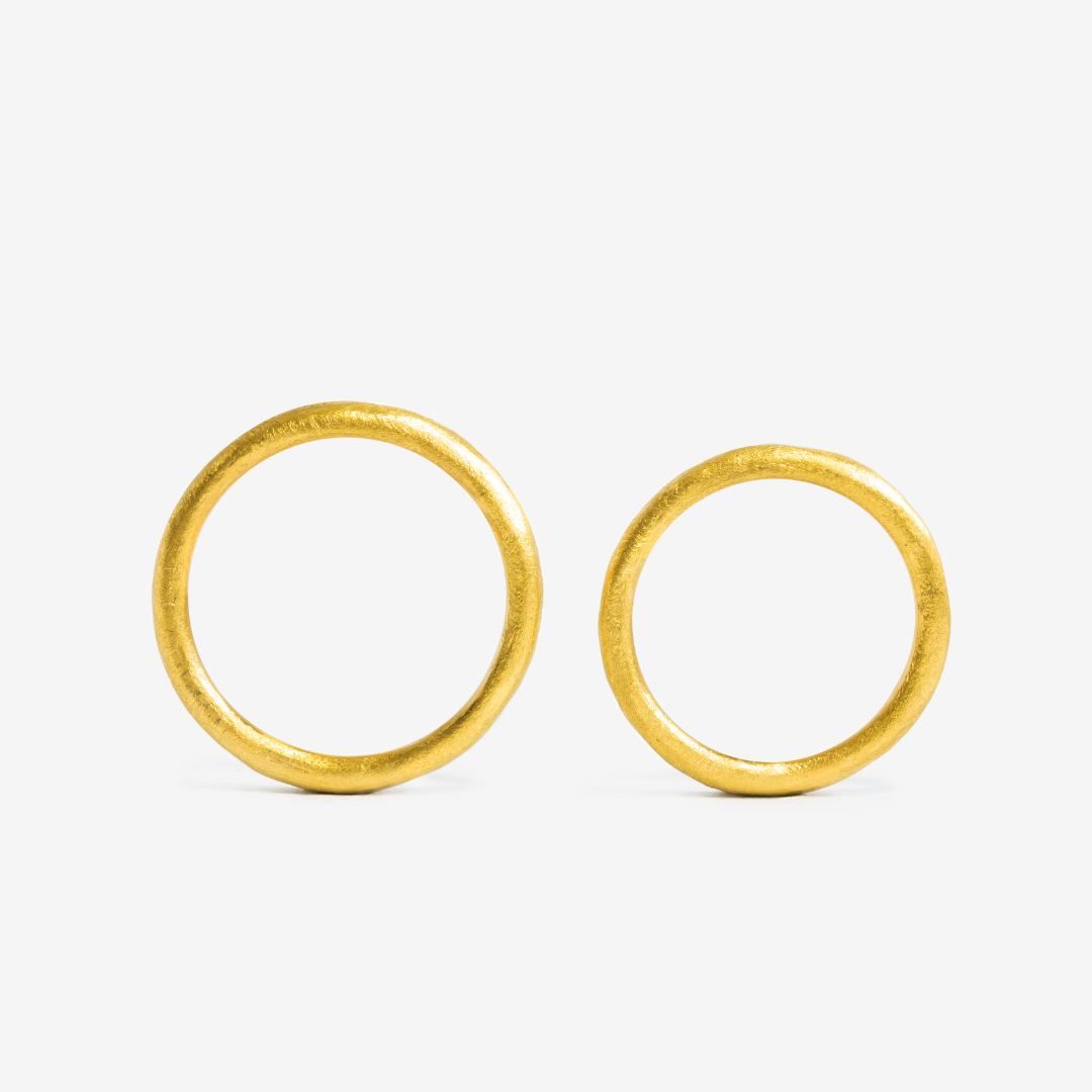 Two 24k gold hand-forged seamless ring on a white background
