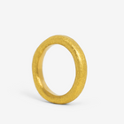 A single 24k gold hand-forged seamless ring on a white background