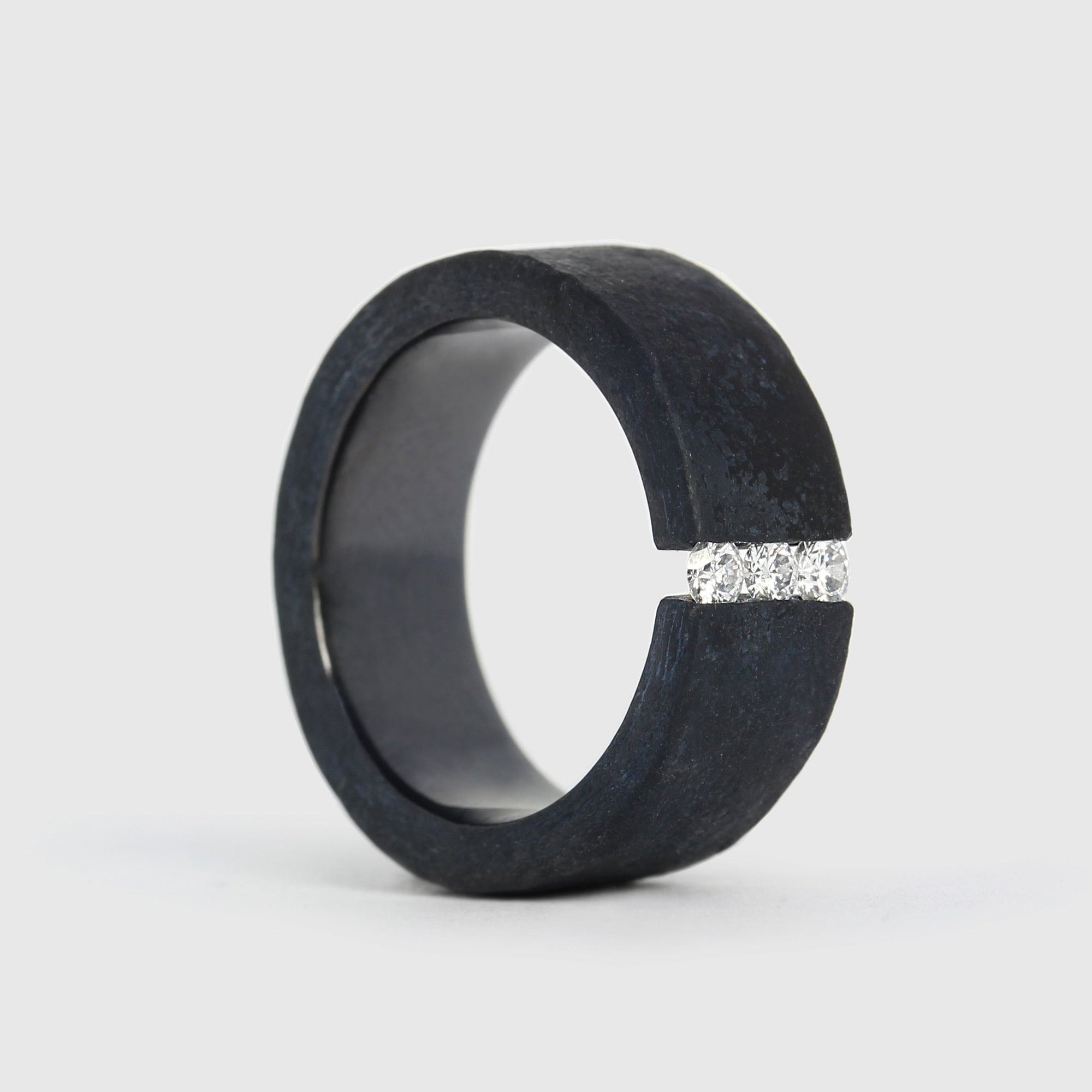 A black niobium ring with a matt finish and a band of white diamonds set on the top surface.