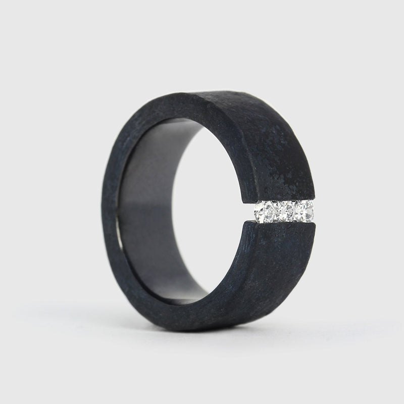 A black niobium ring with a matt finish and a band of white diamonds set on the top surface.