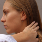 Woman wearing white gold hoop earrings featuring a row of pavé-set diamonds with a total carat weight of ~0.44 ct.