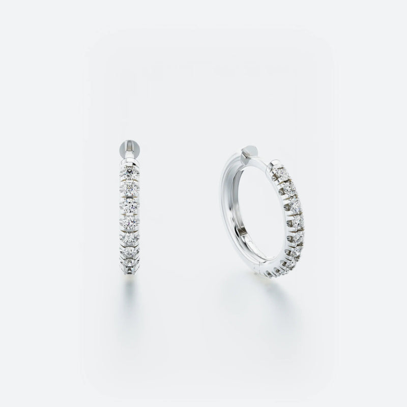 A pair of white gold hoop earrings with pavé-set diamonds around the hoop.