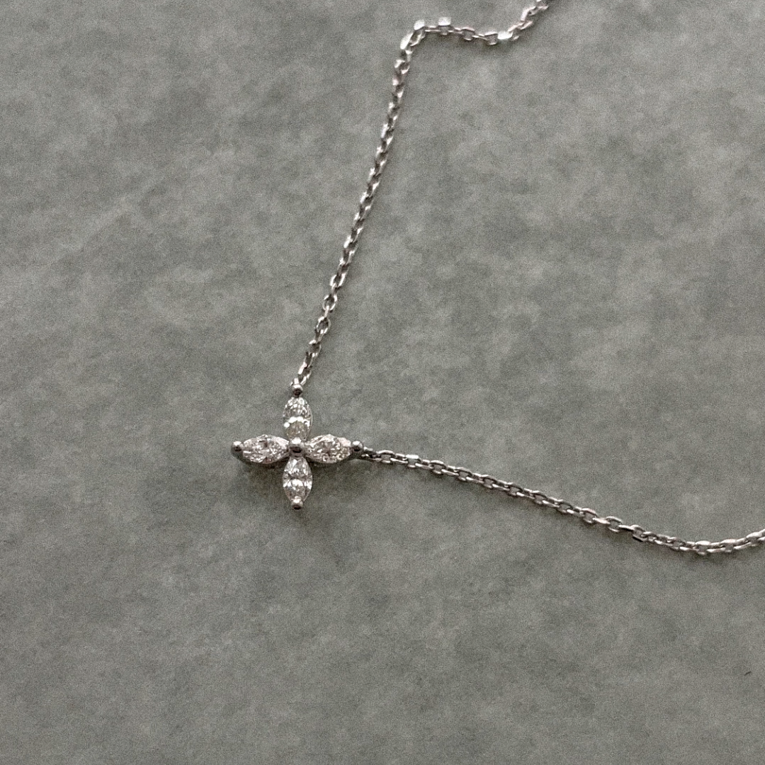 Delicate flower pendant crafted in 14k white gold, adorned with marquise-cut diamonds.