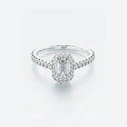 Diamond ring with emerald-cut center stone on a light gray background