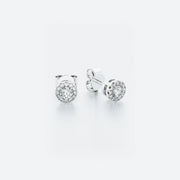 A pair of 14k white gold halo stud diamond earrings with a central diamond surrounded by a halo of pavé-set diamonds.