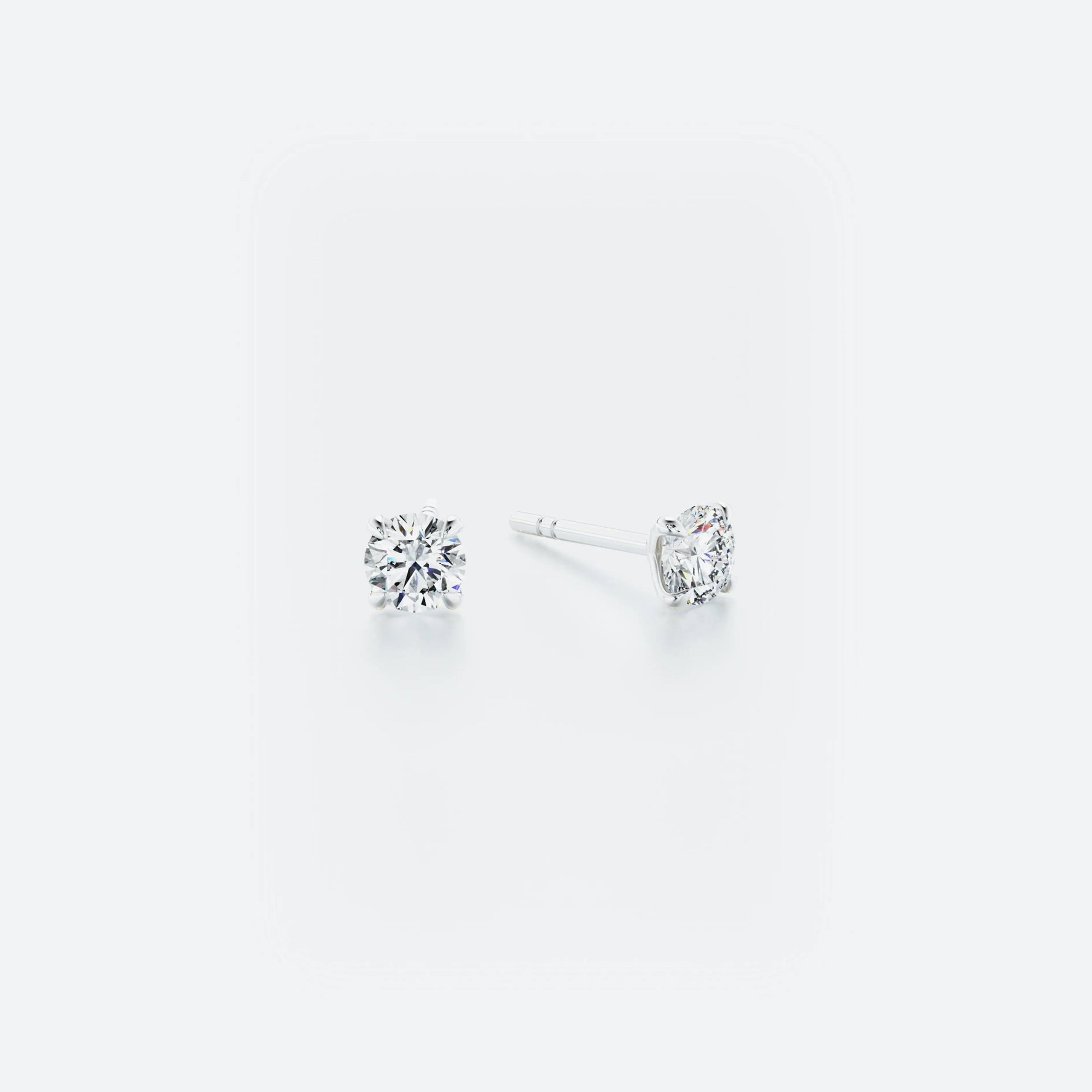 Pair of diamond stud earrings on a white background