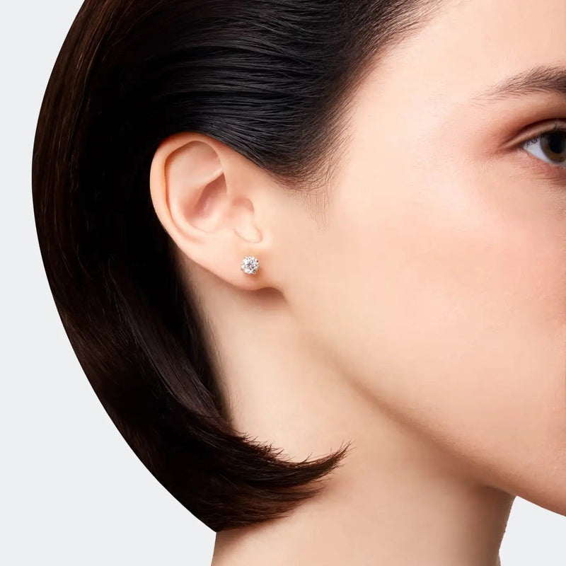 Woman wearing classic stud earrings crafted from 14k white gold, featuring brilliant diamonds with a total weight of 1.00 ct. 