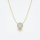 Yellow gold necklace with a round diamond pendant on a light gray background