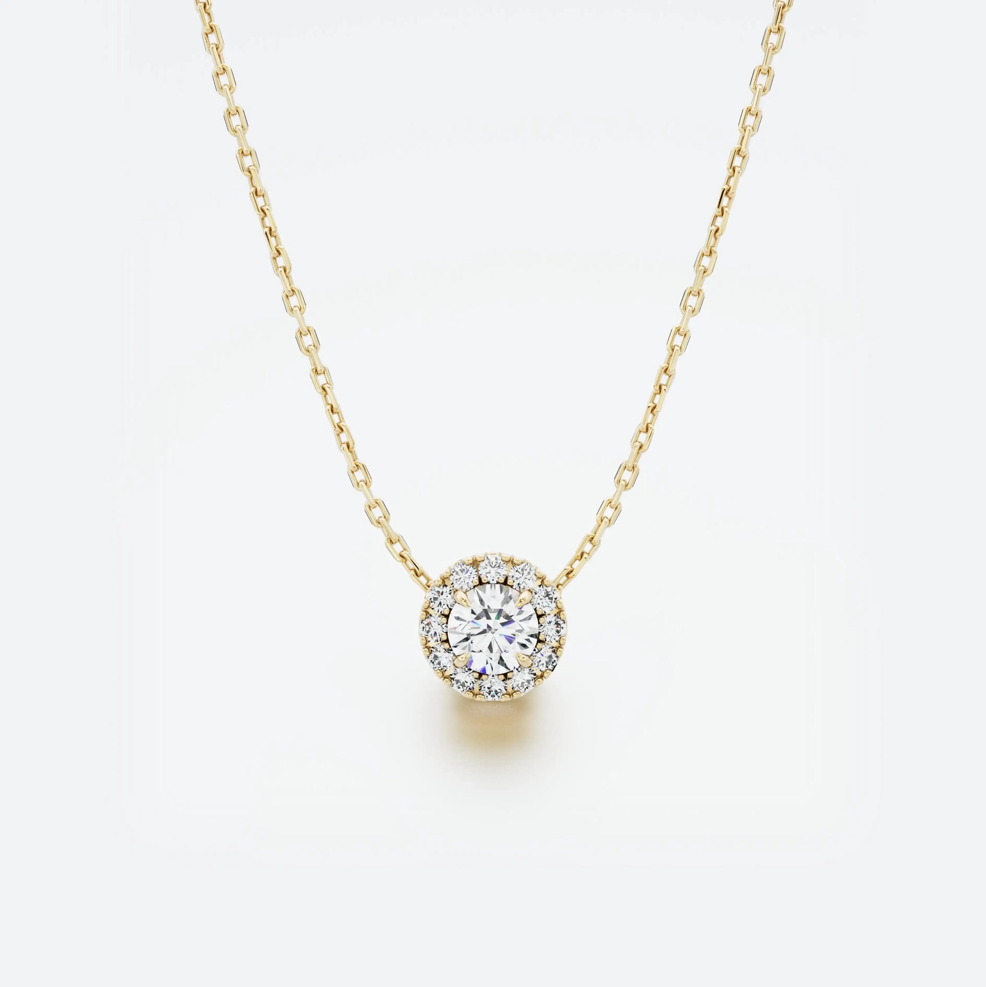 Yellow gold necklace with a round diamond pendant on a light gray background