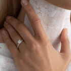 A white gold ring with a large central diamond surrounded by smaller diamonds around the band.