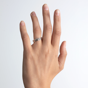 Hand wearing two gold and diamond rings titled "Boy" and "Girl".