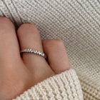 Hand wearing white gold ring with word Mama set with single diamond.