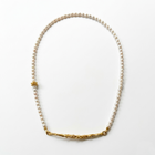 Pearl necklace with gold accents on a white background