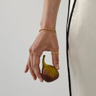 Hand holding a fig with a plain background