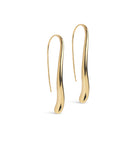 A pair of gold-colored, sculptural drop earrings with a smooth, organic wavy silhouette, displayed on a clean white background.