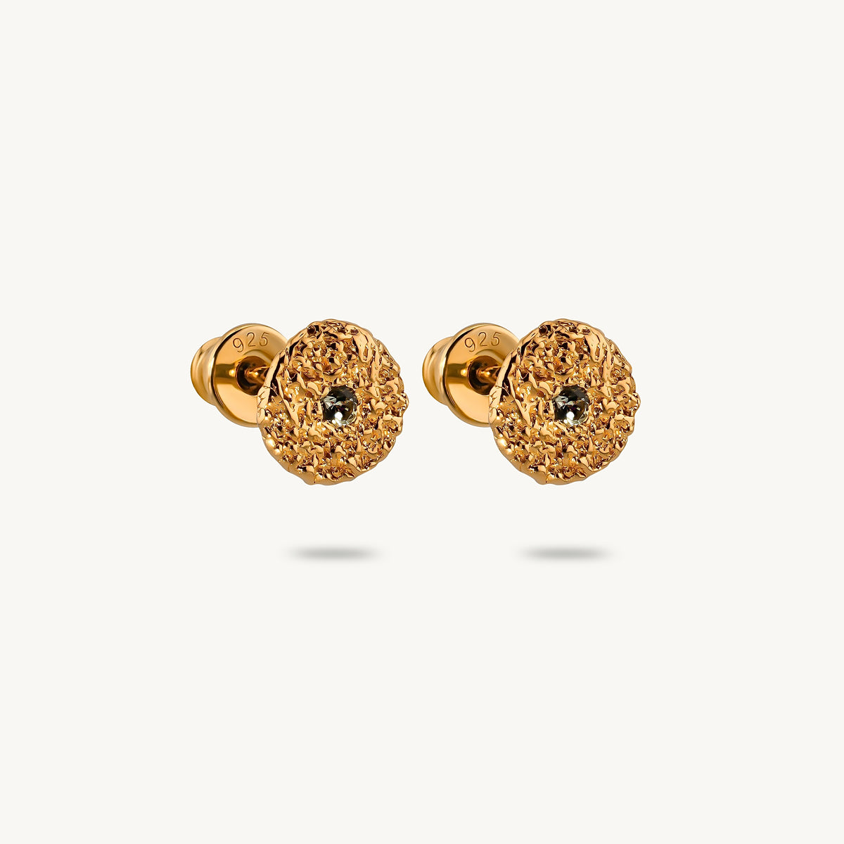 A pair of gold-plated silver stud earrings with circular disc motifs, a central halo of green sapphires, on a clean white background.