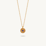Gold-plated silver chain necklace featuring a round, textured disc pendant with a small blue sapphire set in the center.