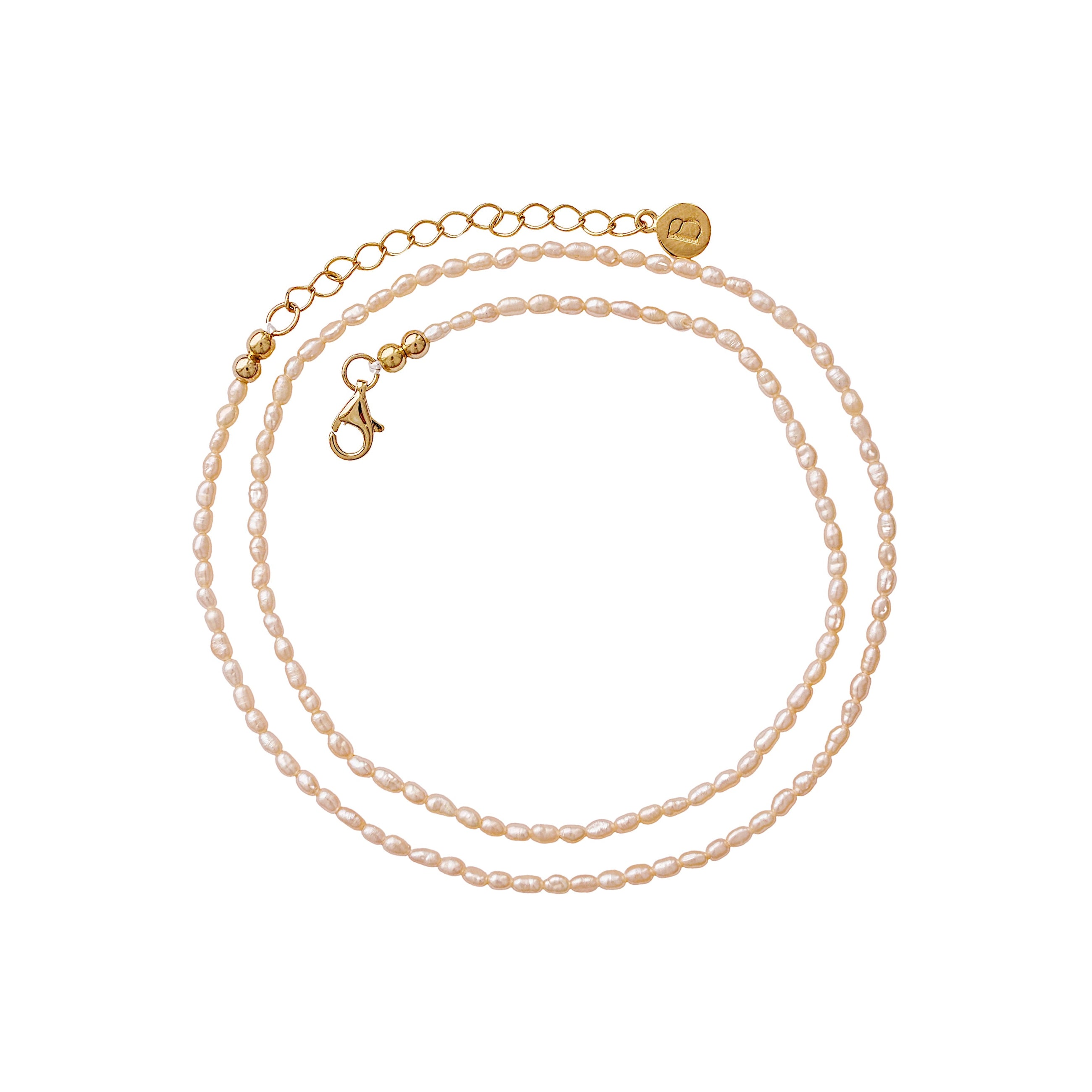 A delicate pearl necklace with gold-plated chain, a lobster clasp, and a small round gold brand tag, displayed on a clean white background.