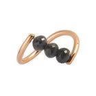 A rose gold ring featuring three faceted dark gray diamond beads set along a curved, open infinity-style band, shown on a plain white background.