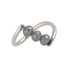 A white gold ring featuring three faceted dark gray diamond beads set along a curved, open infinity-style band, shown on a plain white background.