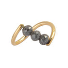 A yellow gold ring featuring three faceted dark gray diamond beads set along a curved, open infinity-style band, shown on a plain white background.