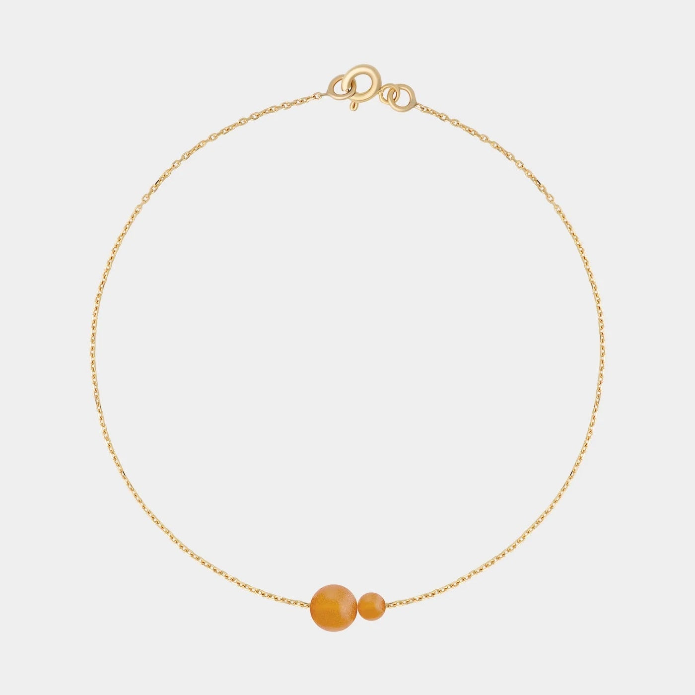 Gold bracelet with two asymmetrical Baltic ambers by Adele Notes.