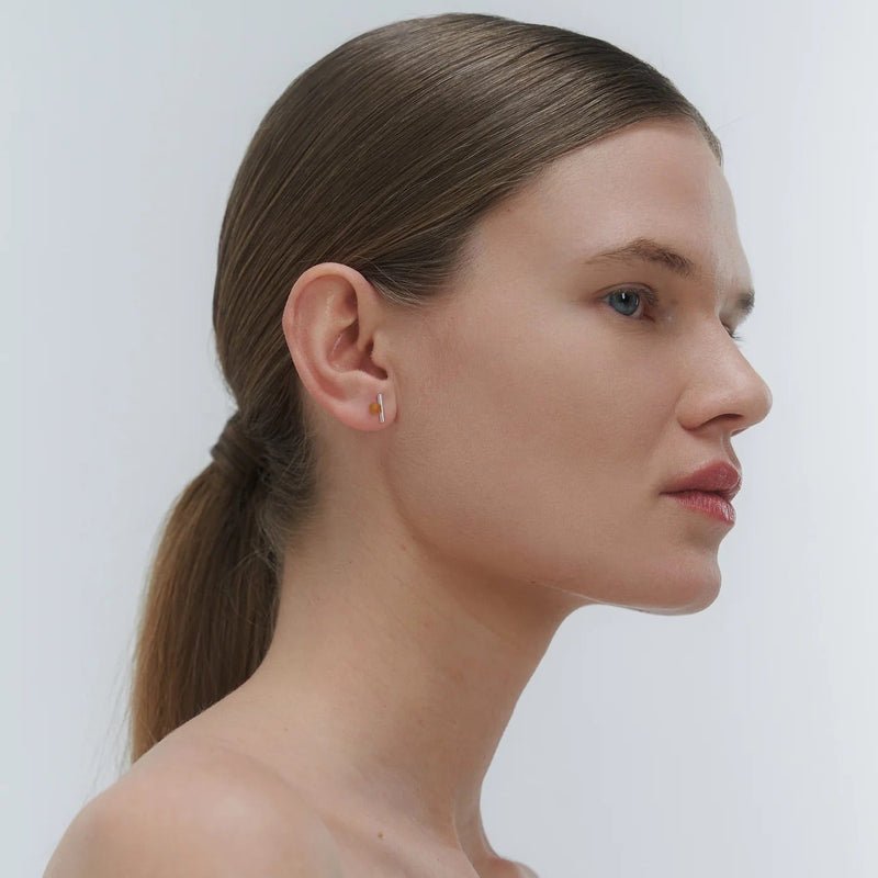 Silver earrings by Adele Notes, featuring a band and small Baltic amber element.