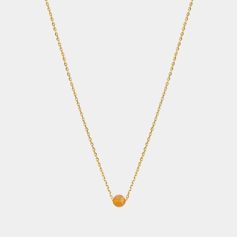 Gold necklace with small Baltic amber pendant by Adele Notes.