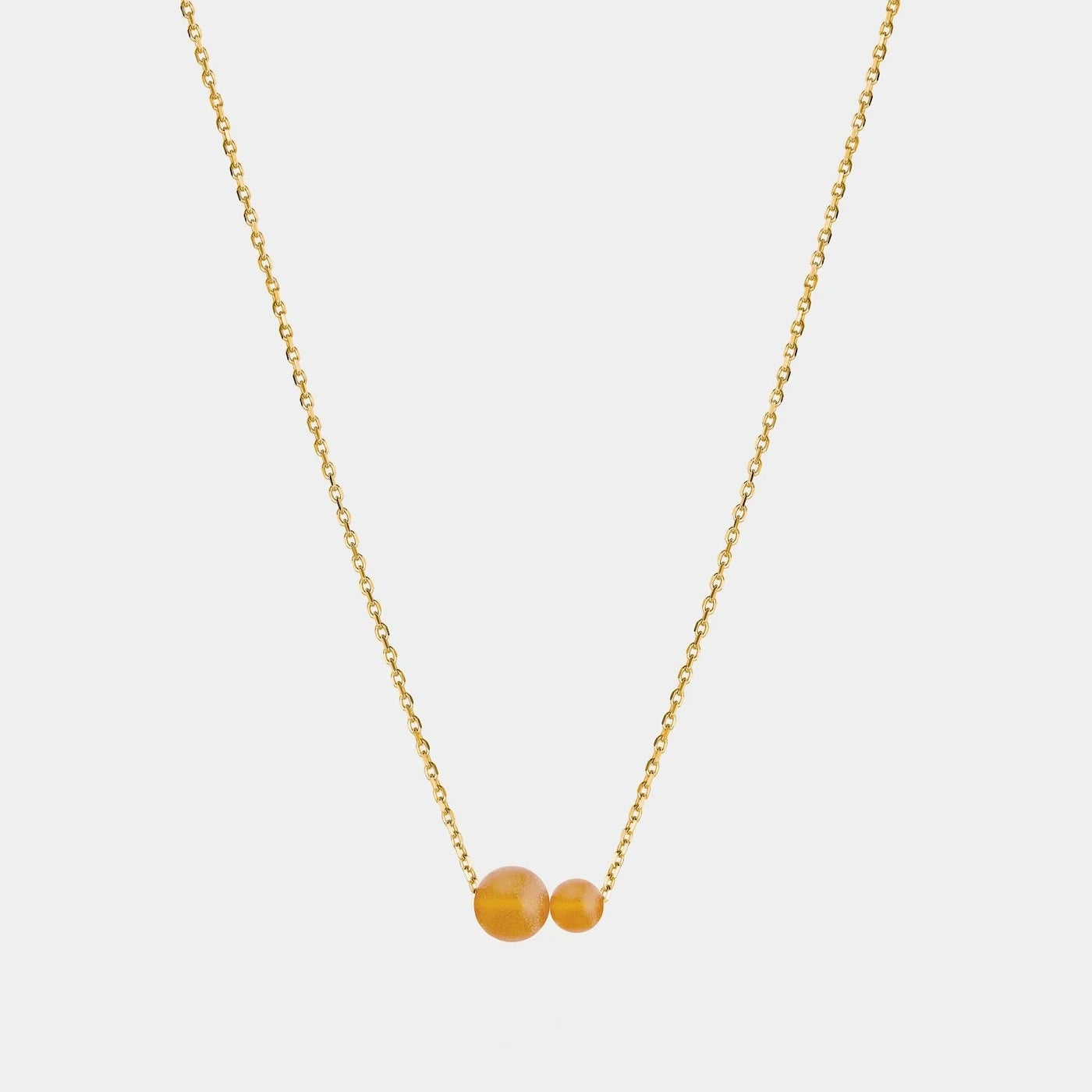 Gold necklace with two asymmetrical Baltic amber pendants by Adele Notes. 