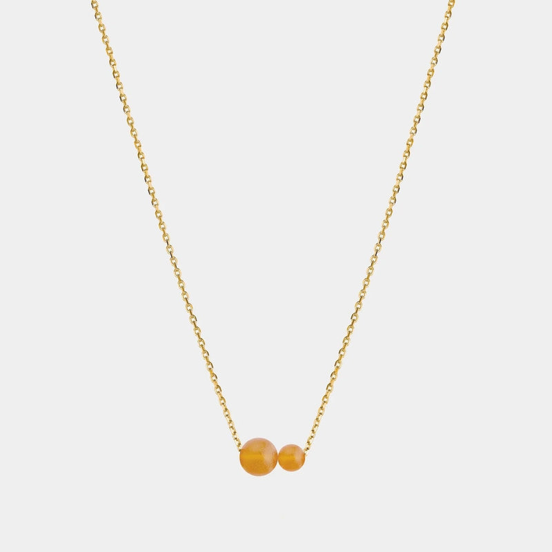 Gold necklace with two asymmetrical Baltic amber pendants by Adele Notes. 