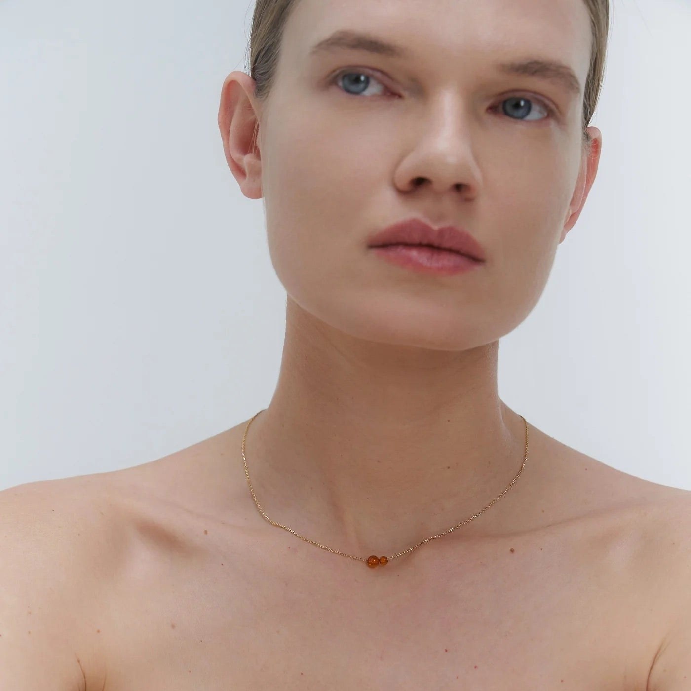 Gold necklace with two asymmetrical Baltic amber pendants by Adele Notes. 