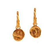 Pair of gold earrings with coin-like designs on a white background