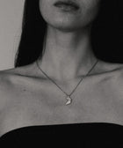 Close-up of a person wearing a necklace with a moon pendant.