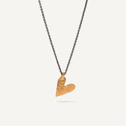 Gold heart-shaped pendant on a black chain against a white background